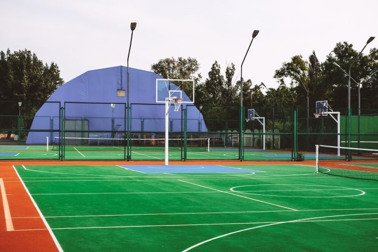 Outdoor sports field with artificial turf for playing tennis and basketball.